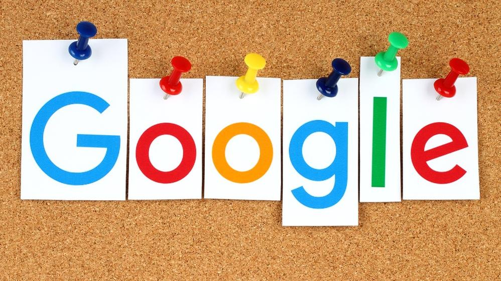 Logo Google diilustrasikan pada potongan kertas yang ditempel di papan tulis